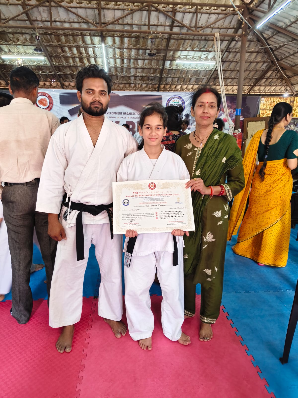 Student receiving black belt certificate with proud parent